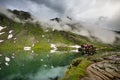 Balea lake and Balea Hotel in spring time with clouds Royalty Free Stock Photo